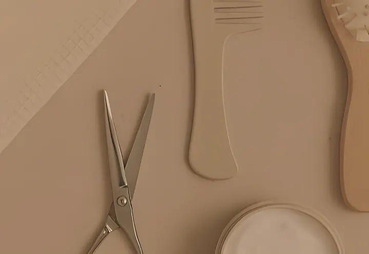 Scissors, comb and brush on oatmeal