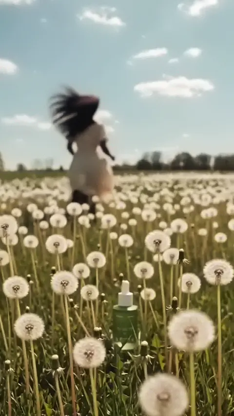 A woman runs through a dandelion field and the Follicle Fuel bottle rises from it