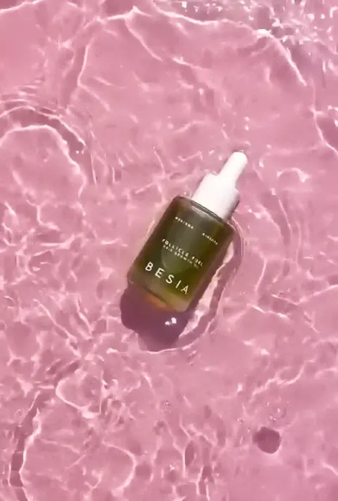 The bottle lands in pink water